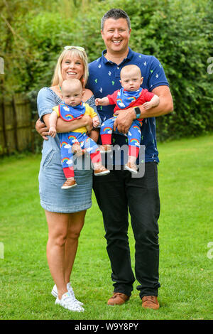 Jennie et riche Powell avec leurs jumeaux Ruben (à gauche) et Jenson, qui célèbrent leur premier anniversaire en rencontrant les équipes de garde-côtes HM pour la première fois depuis que Mme Powell a été évacué par hélicoptère à Oxford de Cornwall, après qu'elle entre en travail à 22 semaines avec ses jumeaux, donnant naissance à la pré-terme survivant le plus jeune des jumeaux nés en Grande-Bretagne. Banque D'Images