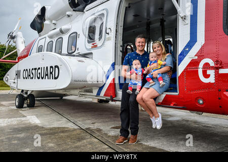 Jennie et riche Powell avec leurs jumeaux Ruben (à gauche) et Jenson, qui célèbrent leur premier anniversaire en rencontrant les équipes de garde-côtes HM pour la première fois depuis que Mme Powell a été évacué par hélicoptère à Oxford de Cornwall, après qu'elle entre en travail à 22 semaines avec ses jumeaux, donnant naissance à la pré-terme survivant le plus jeune des jumeaux nés en Grande-Bretagne. Banque D'Images