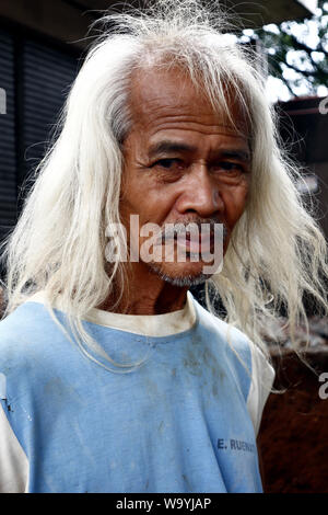 ANTIPOLO CITY, PHILIPPINES - le 12 août 2019 : Un adulte homme de son pays avec de longs cheveux gris pose devant l'appareil photo. Banque D'Images