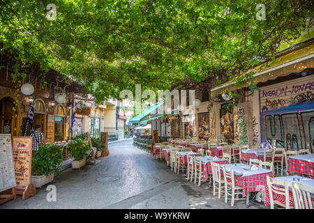 Athènes, Grèce - Août 4, 2019 : Plaka, ruelle avec un écrin de verdure et à l'extérieur de taverne grecque tables dans centre historique Banque D'Images