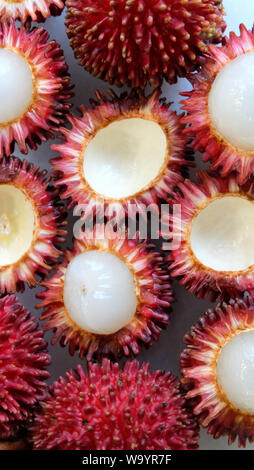 Peau extérieure et une chair blanche pulasan fruits. Vue d'en haut. Nom scientifique Nephelium ramboutan-pulasan akea, est un fruit tropical rouge qui est étroitement liée Banque D'Images