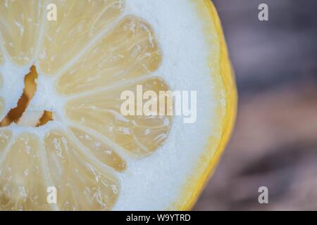Gros plan sur un point de mise au point sélectif d'un seul citron coupé en tranches un arrière-plan flou Banque D'Images