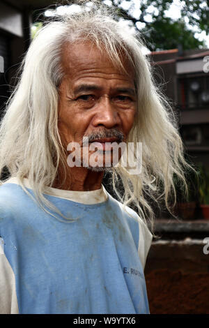 ANTIPOLO CITY, PHILIPPINES - le 12 août 2019 : Un adulte homme de son pays avec de longs cheveux gris pose devant l'appareil photo. Banque D'Images