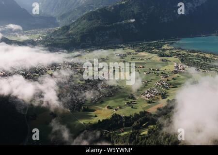 Belle photo aérienne d'une ville entourée de montagnes couvertes avec brouillard Banque D'Images
