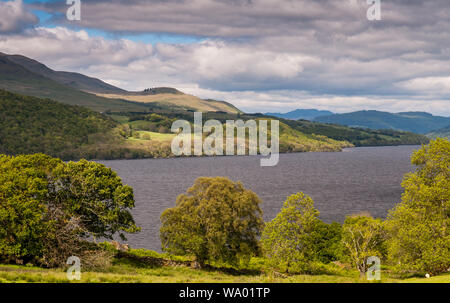 Montagnes couvertes de forêts s'élèvent sur les rives du Loch Tay, dans le Perthshire Highlands d'Ecosse. Banque D'Images