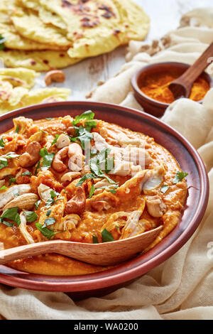 Soupe Mulligatawny avec la viande de poulet et le lait de coco saupoudré de cajou frits dans un bol avec chapati sur une table en bois blanc, Indien et anglais cu Banque D'Images