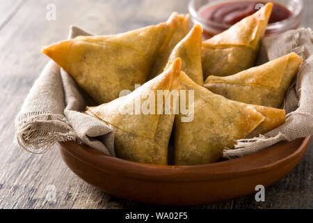 Samsa ou samossas à la viande et les légumes dans un bol sur la table en bois. La cuisine indienne traditionnelle. Banque D'Images