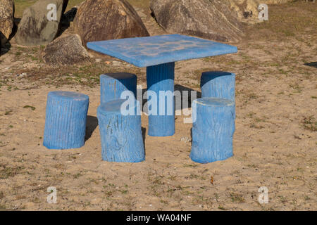 Un ensemble de tables de pique-nique en béton bleu qui ressemble à souches d'arbre sur la plage à Kuala Terengganu, Malaisie. Banque D'Images