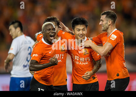 Les joueurs de Wuhan Zall célébrer après avoir marqué contre Shandong Luneng Taishan en leur 22e match au cours de l'Association de football chinoise 2019 Super League (CSL) dans la ville de Wuhan, province du Hubei en Chine centrale, 15 août 2019. Wuhan Zall Shandong Luneng Taishan défait 2-1. Banque D'Images