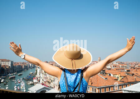 Vue arrière de l'femelle Outstretching ses main sur le Grand Canal à Venise Banque D'Images