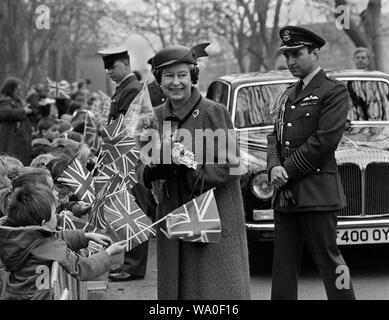 Son Altesse Royale la Reine Elizabeth II accueilli par les enfants de brandir le drapeau des années 1980 Banque D'Images