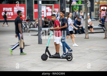 L'E-scooter, scooter électrique, scooter de location, la conduite, à l'Alexander Platz, à Berlin, les gens de remorquage sur un scooter, Banque D'Images