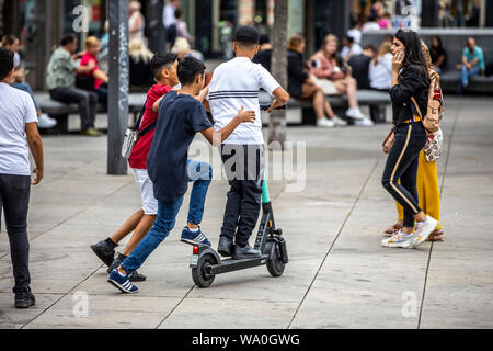 L'E-scooter, scooter électrique, scooter de location, la conduite, à l'Alexander Platz, à Berlin, 3 personnes sur un scooter, Banque D'Images