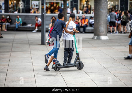 L'E-scooter, scooter électrique, scooter de location, la conduite, à l'Alexander Platz, à Berlin, 3 personnes sur un scooter, Banque D'Images