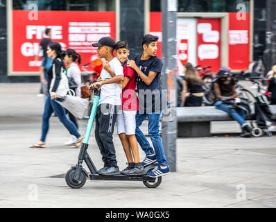 L'E-scooter, scooter électrique, scooter de location, la conduite, à l'Alexander Platz, à Berlin, 3 personnes sur un scooter, Banque D'Images