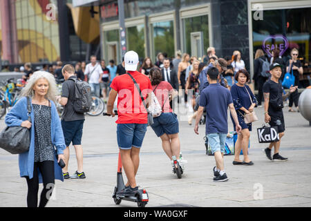 L'E-scooter, scooter électrique, scooter de location, la conduite, à l'Alexander Platz, à Berlin, entre les piétons, Banque D'Images