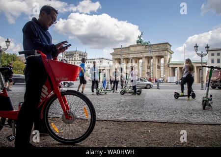 Homme avec location e-bike de Uber, scooter électrique, scooter électrique, scooter électrique, en face de la porte de Brandebourg à Berlin, Banque D'Images