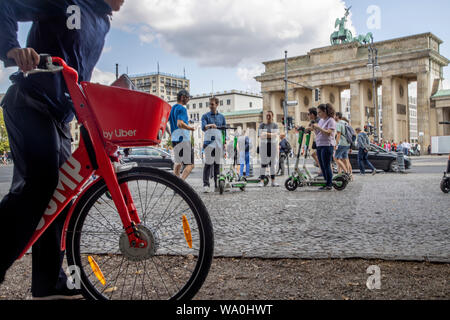 Homme avec location e-bike de Uber, scooter électrique, scooter électrique, scooter électrique, en face de la porte de Brandebourg à Berlin, Banque D'Images