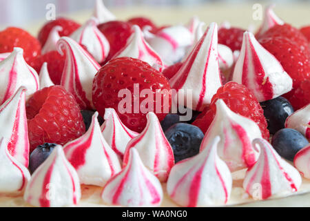 Gâteau au fromage délicieux, frais Meringue garni de framboises, fraises et bleuets. Banque D'Images