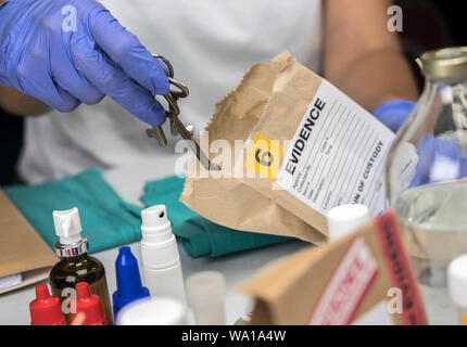 Agent de police scientifique examine les clefs de test de scène de crime, conceptual image Banque D'Images