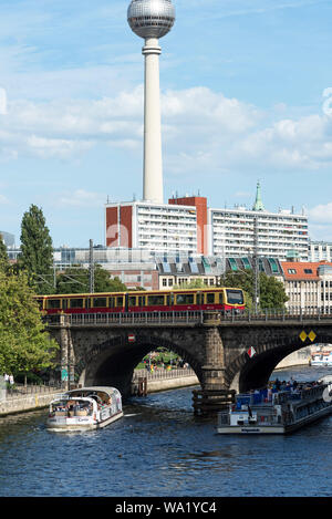 Les bateaux d'excursion sur la rivière Spree en passant sous le pont de l'Île Musée Stadtbahn avec la tour de la télévision dans la distance, Berlin, Allemagne. Banque D'Images