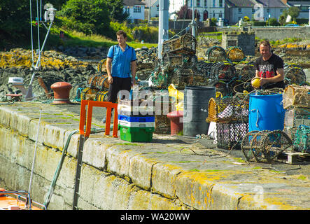 8 août 2019 Hommes travaillant sur le port côté quai dans le petit village de pêcheurs de Ardglass dans le comté de Down en Irlande du Nord sur une chaude journée d'été. Banque D'Images