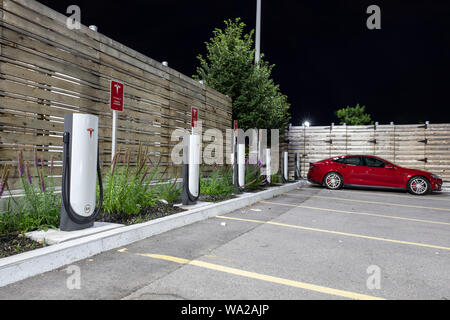 Tesla Model S la suralimentation dans la nuit. Banque D'Images