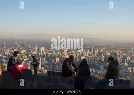 Les gens assis à point de vue sur la colline de San Cristobal avec vue sur Santiago, Chili Banque D'Images