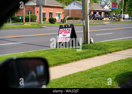 Un chauffeur d'un signe en plastique repliable en bordure de l'espace publicitaire pour la location. Banque D'Images