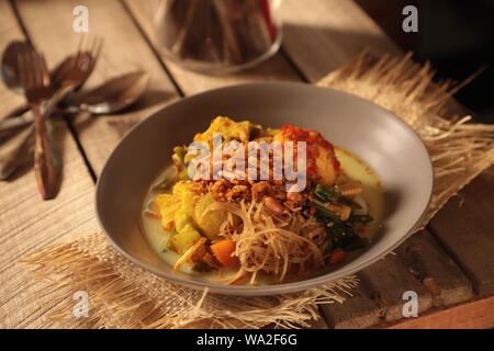 Lontong Sayur Medan. Plat végétarien de gâteau de riz avec des oeufs, les vermicelles et légumes soupe curry de Medan, au nord de Sumatra. Banque D'Images