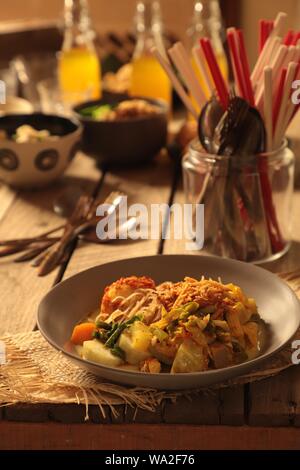 Lontong Sayur Medan. Plat végétarien de gâteau de riz avec des oeufs, les vermicelles et légumes soupe curry de Medan, au nord de Sumatra. Banque D'Images