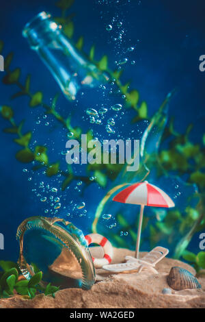 Parasol et chaise longue sous l'eau avec des bulles et l'algue. Les villes de noyade et le réchauffement de la concept. La vie encore conceptuel avec miniatures. Banque D'Images