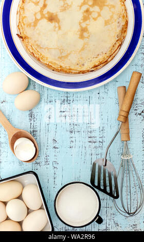 La cuisson des crêpes. Ingrédients, vaisselle et ustensiles de cuisine pour des crêpes. Focus sélectif. Banque D'Images