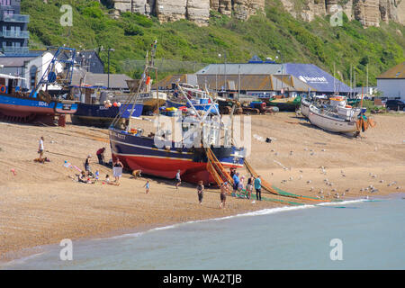 Bateau de pêche Hastings d'être tiré jusqu'à l'Ancien hôtel de ville Stade bateau de pêche plage, les gens à jeter à crabes capturés dans des filets de pêche, East Sussex, Banque D'Images