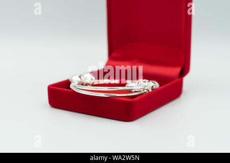 Bébé Cadeaux est argent bracelet de luxe en boîte rouge, sur fond blanc. Banque D'Images