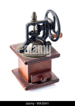 Vintage rusty, poivre noir en bois d'une meuleuse ou d'un moulin avec un pignon poignée mécanique isolé sur un fond blanc. Banque D'Images