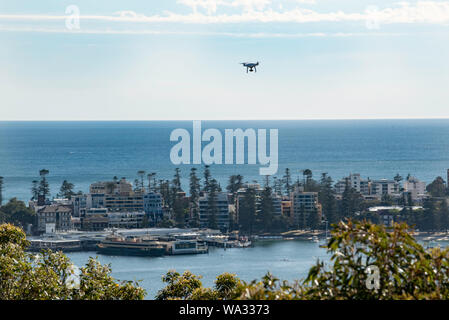 Avec un Ferry Sydney amarré à l'arrière-plan à Manly wharf et la banlieue de Manly derrière elle un bourdon suspendu au-dessus avec une vue panoramique Banque D'Images