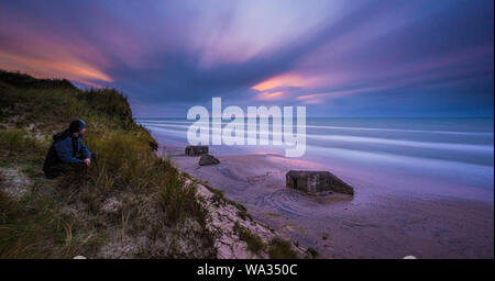 Une longue exposition d'anciennes fortifications bunker sur une plage de sable. Banque D'Images