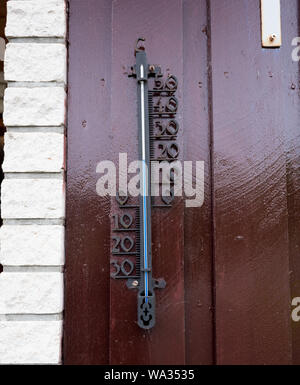 Un thermomètre métal sur un mur marron indiquant 20 degrés celsius. Banque D'Images