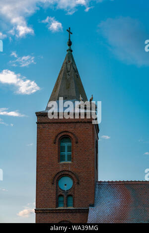 Église dans Guelpe, Allemagne avec deux cigognes reproducteurs sur le toit de la tour de l'horloge Banque D'Images