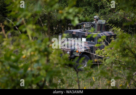 Les soldats de l'armée américaine de la Force d'opposition (OPFOR), dissimuler leurs Humvee dans le pinceau au début de l'exercice de la force de travail sur le point culminant pendant les résoudre XII à Hohenfels Domaine de formation, l'Allemagne le 15 août 2019. Résoudre combinées de l'armée américaine est une publication semestrielle de l'Europe et 7e armée dirigée par l'exercice de la commande de formation destiné à évaluer et à certifier l'état de préparation et l'interopérabilité des forces nous mobiliser pour l'Europe en faveur de la résolution de l'Atlantique. (U.S. Photo de l'armée par le Sgt. Thomas Mort) Banque D'Images