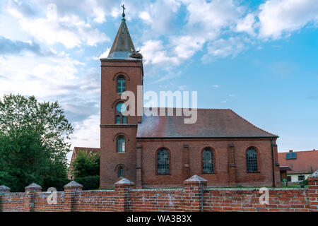 Église dans Guelpe, Allemagne avec deux cigognes reproducteurs sur le toit de la tour de l'horloge Banque D'Images