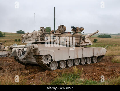 D'un M1 Abrams tank appartenant au 3e Bataillon, 66e régiment de blindés, 1st Armored Brigade Combat Team, 1re Division d'infanterie, d'attente dans une ligne de réservoirs de commencer la prochaine itération d'une mission de formation de l'agression sur une gamme à Grafenwoehr Domaine de formation, l'Allemagne, le 8 août 2019. Cet exercice fait partie de l'ABCT 1événement de formation finale avant de participer à résoudre combiné XII. (U.S. Photo de l'armée par le sergent. Adam Decker) Banque D'Images