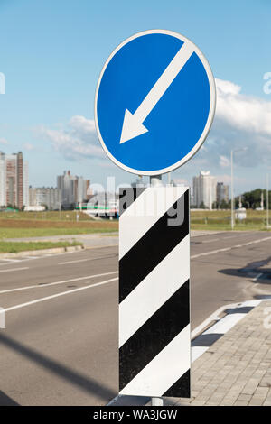 Roadsign déviation sur la gauche, debout au milieu de la route Banque D'Images