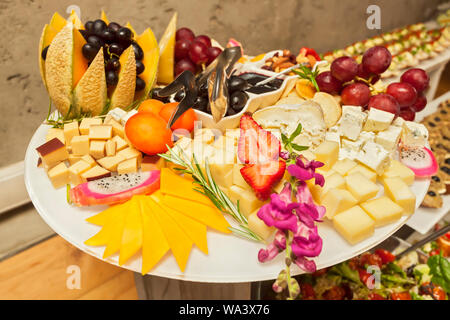 Fraises fruits frais, le raisin et le melon sur des brochettes avec divers fromages de moustiques - morsure unique de servir - Parti pris finger food Banque D'Images
