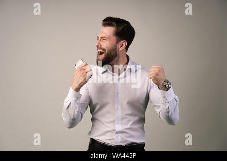 Portrait de jeune homme très excité, célébrer la victoire avec les mains et crier. Chance extrême. Banque D'Images