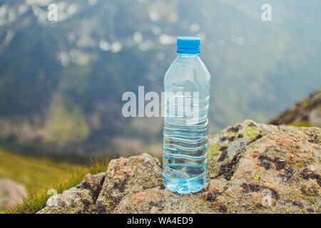 L'eau pure dans des bouteilles en plastique sur la pierre contre l'arrière-plan d'une vue pittoresque sur les montagnes Tatras Zakopane Kasprowy Wierch dans l'été. Billet d Banque D'Images