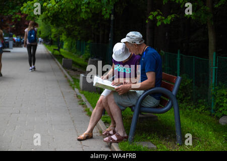 Polish Tatras, Pologne 12 juin 2019 : Portrait de deux élégantes actives traveler holding la carte en mains, choisir la bonne route pour les montagnes, assis sur Banque D'Images