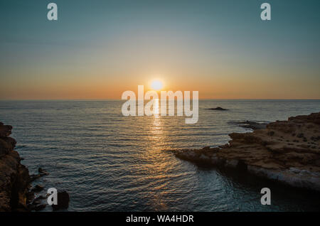 Le coucher du soleil sous le beau ciel bleu sur la plage Banque D'Images