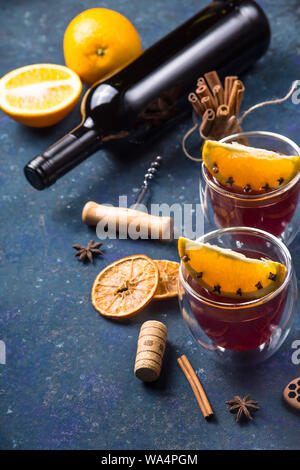 Deux verres de vin chaud avec Clint tranches d'orange parmi les ingrédients pour la cuisine et une bouteille de vin Banque D'Images
